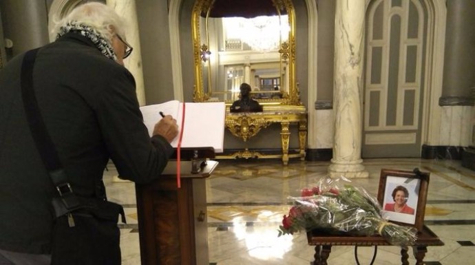 Un hombre firma en el libro de condolencias.