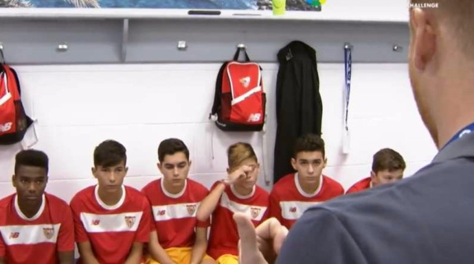 Los jugadores del Sevilla F.C. escuchan atentos al entrenador.