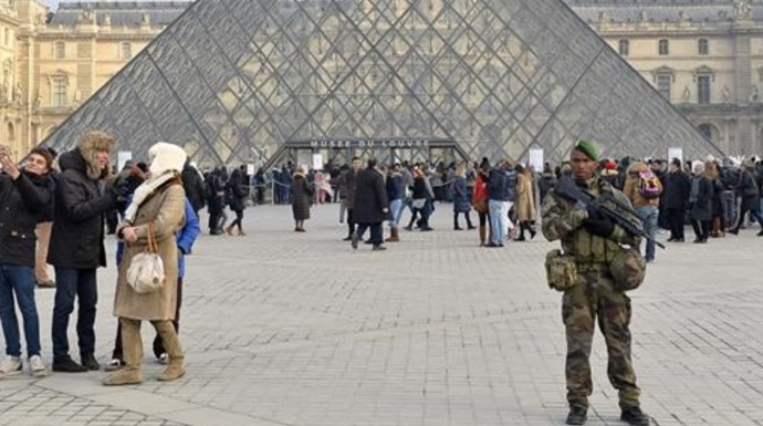 Un militar vigilando la visitada pirámide del Museo del Louvre.