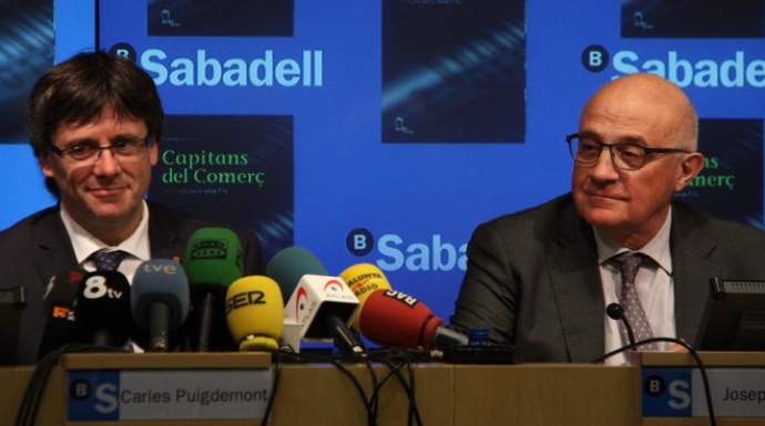 Carles Puigdemont en un acto con el presidente del Banco de Sabadell, Josep Oliú.