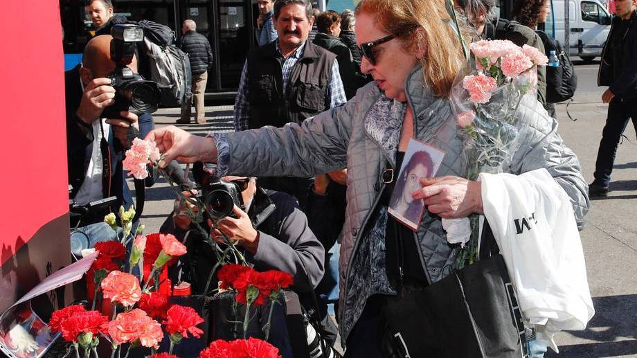 Una mujer deposita unas flores en un altar improvisado a las puertas de la estación de Atocha