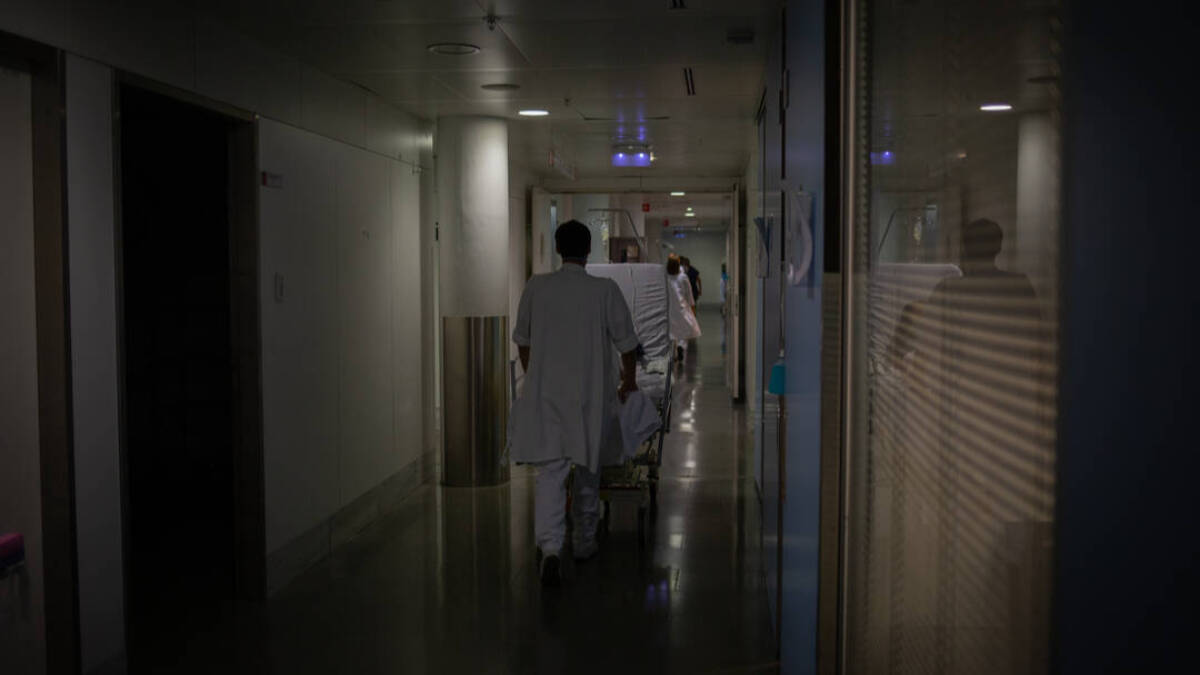 Profesional sanitario traslada una cama móvil en la Unidad de Cuidados Intensivos –UCI- del Hospital de la Santa Creu i Sant Pau, integrado en la Red Hospitalaria de Utilización Pública de Catalunya, en Barcelona.