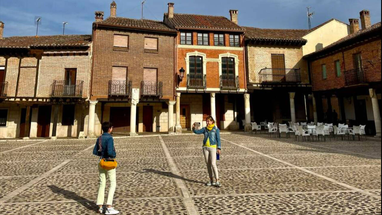 Imagen de dos turistas fotografiándose en la Plaza Vieja de Saldaña (Palencia)