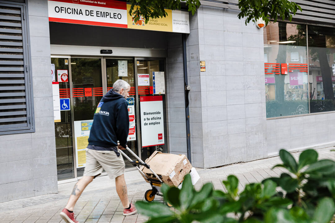 Un repartidor pasa por la oficina del paro de Paseo de las Acacias, en Madrid (España).  Fuente: Europa Press.