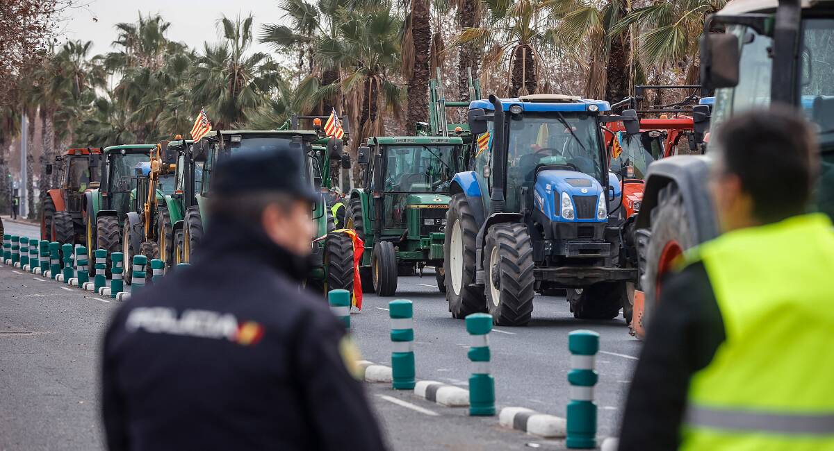 Un agente de Policía Nacional frente a una concentración de tractores en la avenida Germans Machado de Valencia