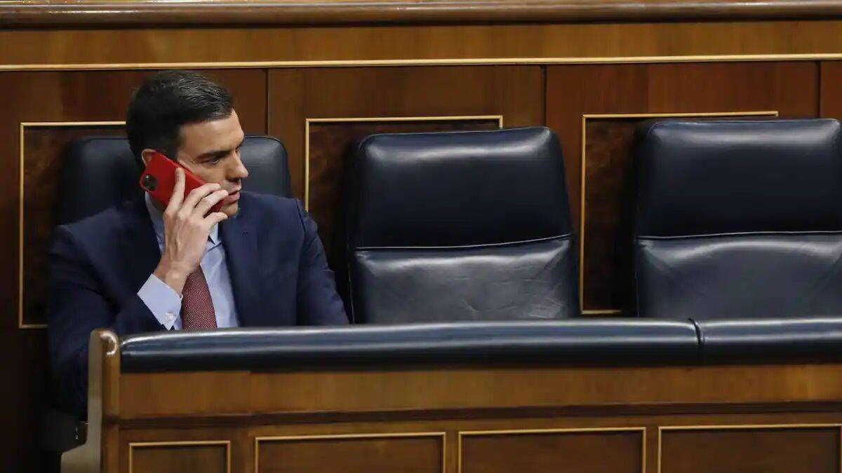 El presidente del Gobierno y líder del PSOE, Pedro Sánchez, habla por teléfono en el Congreso de los Diputados.