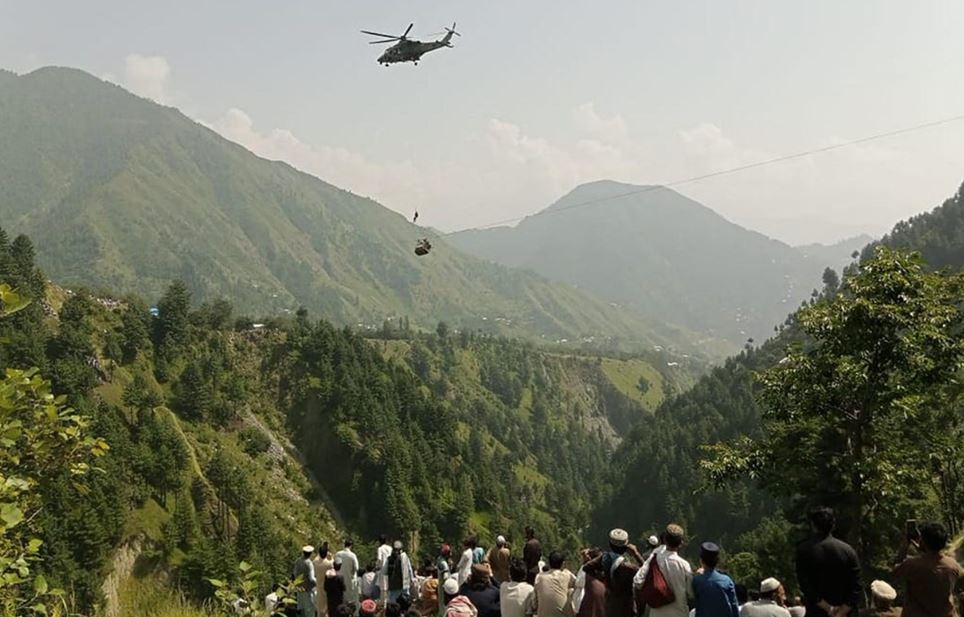 Suceso del teleférico en Pakistán, colina con aldeanos siguiendo el rescate