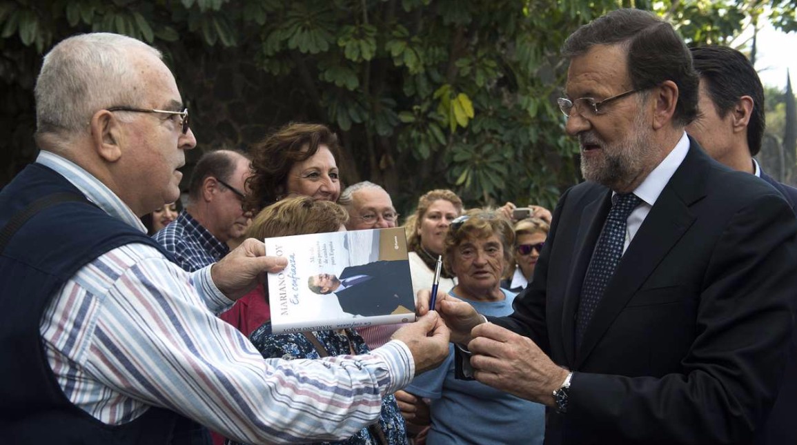 Rajoy firma un ejemplar de su libro a un simpatizante.
