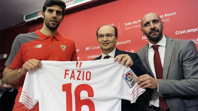 El jugador Federico Fazio junto al presidente y al director deportivo del Sevilla. 