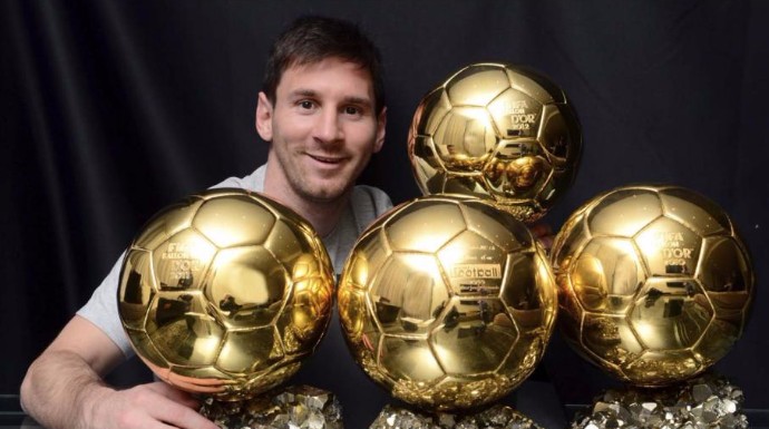 El futbolista Leo Messi posando con sus cuatro trofeos. 