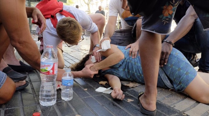 Una mujer herido recibe ayuda de varios viandantes.