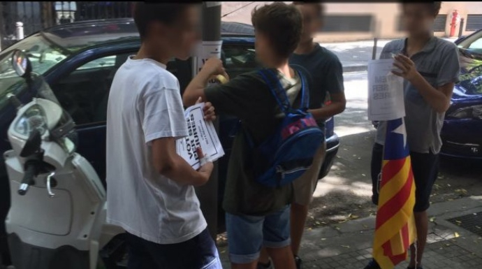 Varios menores repartiendo material de la campaña a favor del SÍ en el referéndum ilegal.