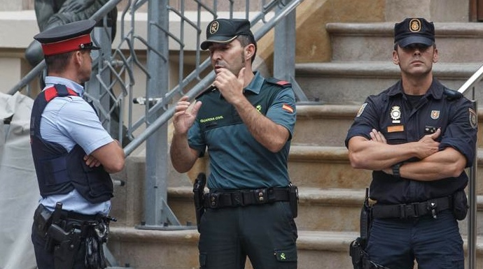 Un mosso, un guardia civil y un policía nacional, este martes frente a la Delegación del Gobierno en Barcelona.