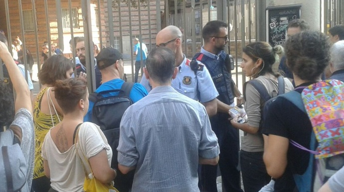 Dos mossos d'Esquadra precientando un colegio en Barcelona. (Twitter Iñaki García)