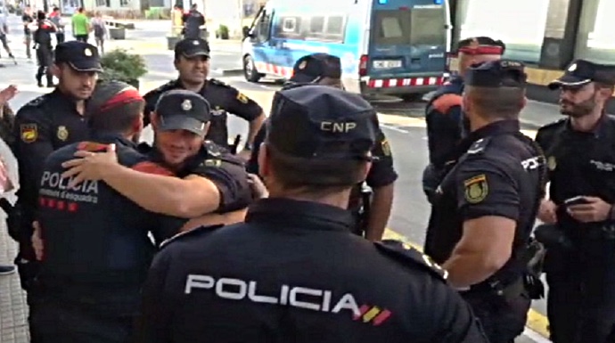 Policías Nacionales y Mossos se abrazan tras dejar el hotel donde fueron acosados.