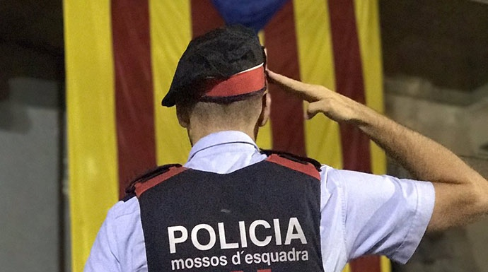 Albert Donaire, líder de los mossos rebeldes, rinde honores a una estelada, símbolo de los independentistas.