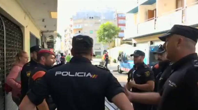 Mossos y policías conversan en una de las localidades de Barcelona en la que los agentes fueron expulsados de sus hoteles.