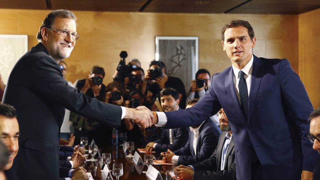 Rajoy y Rivera estrechándose la mano ante las cámaras.