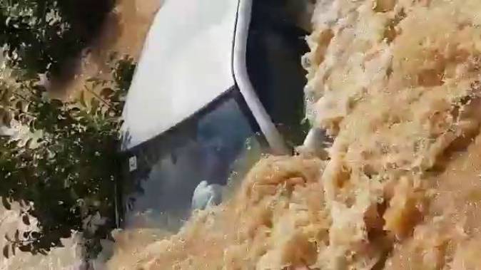 Imagen del coche atrapado en la inundación del campo en Alginet