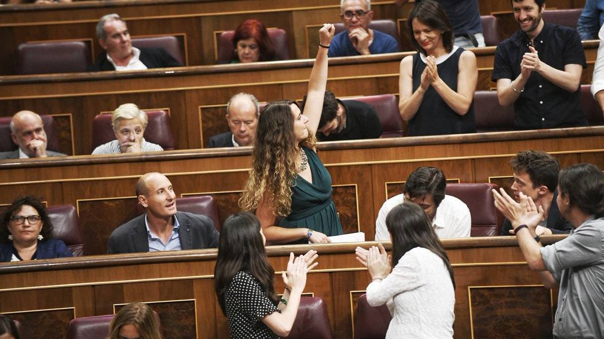 La portavoz adjunta de Podemos, Noelia Vera, saluda puño en alto en la bancada morada.