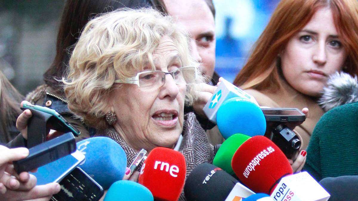 La alcaldesa de Madrid, Manuela Carmena, rodeada de micrófonos.