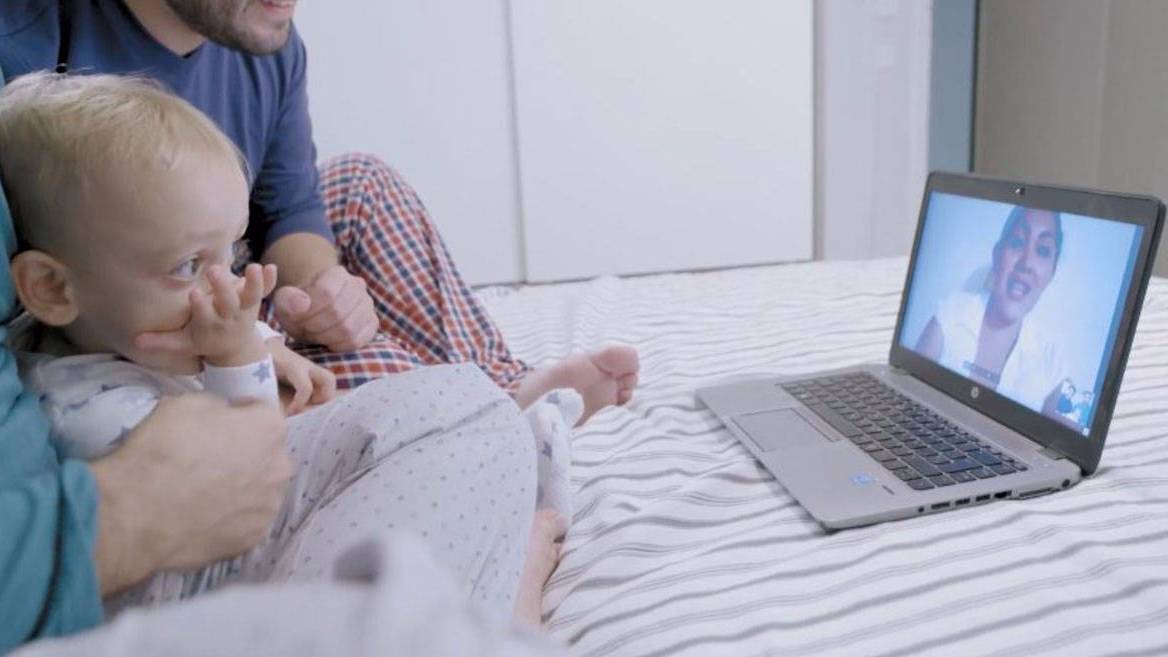 El pequeño Gonzalo saluda a su madre biológica por la pantalla de un ordenador.