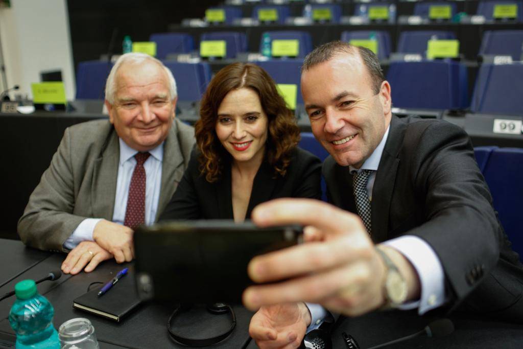 Díaz Ayuso, con el candidato del Partido Popular Europeo a la Presidencia de la Comisión Europea, Manfred Weber (sujetando el teléfono)