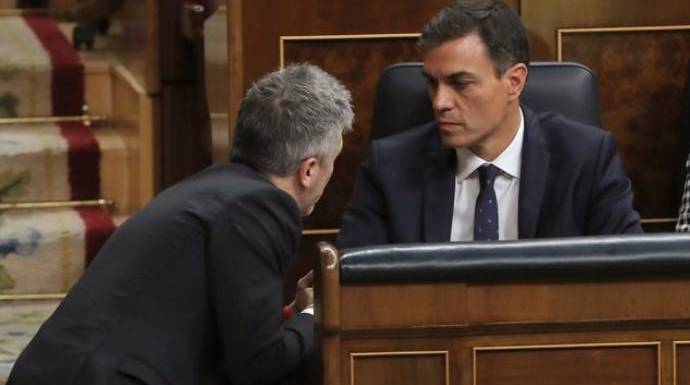 El ministro Marlaska conversa con Sánchez en su escaño.