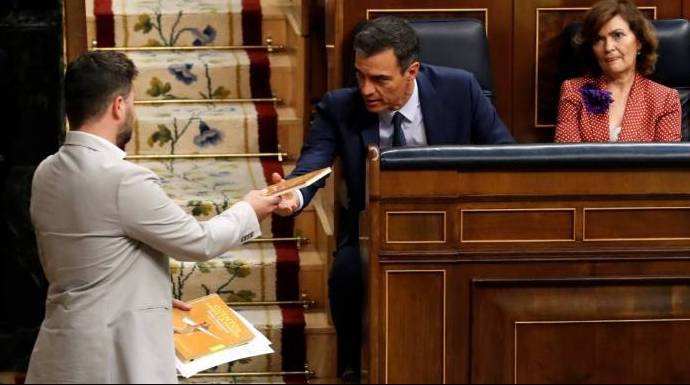 Rufián entregando un libro a Sánchez en un pleno del Congreso.