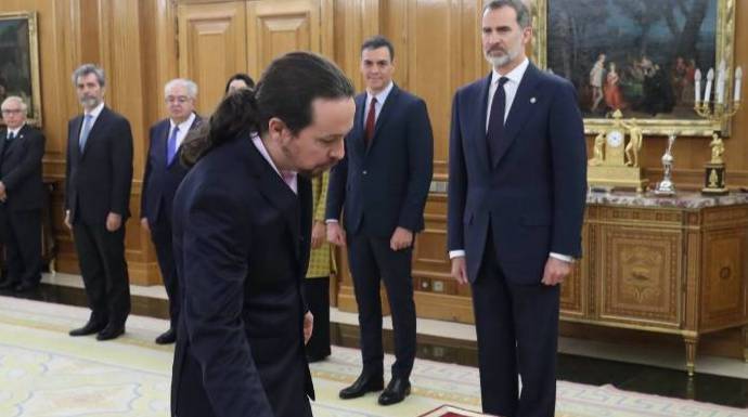 Pablo Iglesias promete su cargo ante el Rey con la mirada atenta de Sánchez.