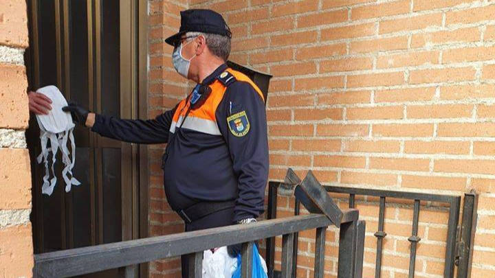 Un policía local entregando mascarillas a domicilio en Sotillo de la Adrada, en Ávila.