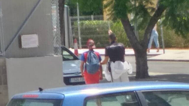 Un agente de la Policía Nacional devuelve a uno de los fugados -con gorra y camiseta roja- al hospital de campaña/FOTO: L.R.V.