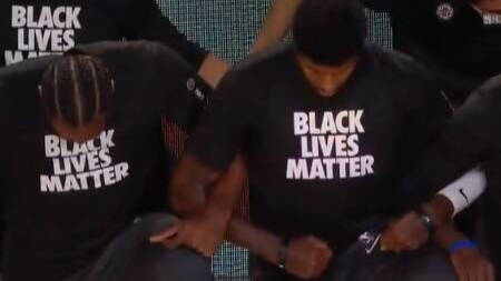 Jugadores de los Lakers escuchan, de rodillas y con camiseta de Black Lives Matter, el himno estadounidense. 
