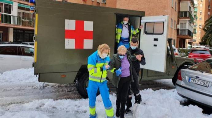 Miembros de la Sanidad Militar trasladan a una anciana en una ambulacia del Ejército en plena nevada por Filomena.