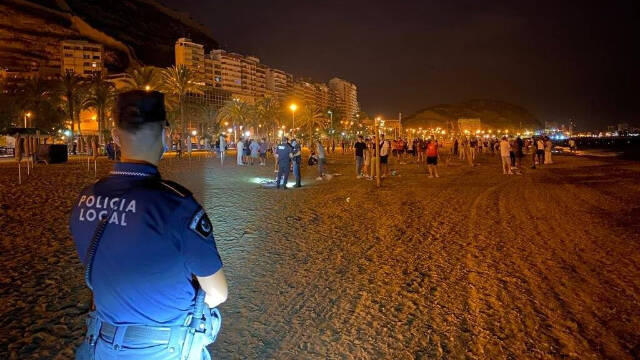 Los agentes de la Policía Local de Alicante disolviendo botellones en la Playa del Postiguet