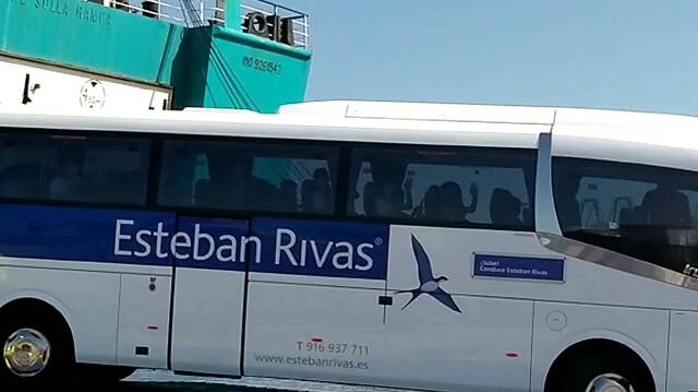 Los jóvenes saludando desde el autobús que los ha recogido dentro del barco