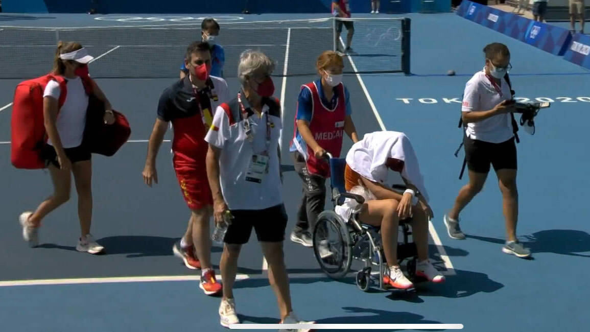 Paula Badosa, en el momento de ser retirada de la pista en silla de ruedas. 