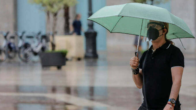 Una persona sostiene un paraguas mientras llueve