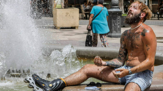 Un hombre se refresca en una fuente del centro de Valencia para soportar las altas temperaturas, a 12 de julio de 2021, en Valencia, Comunidad Valenciana (España).