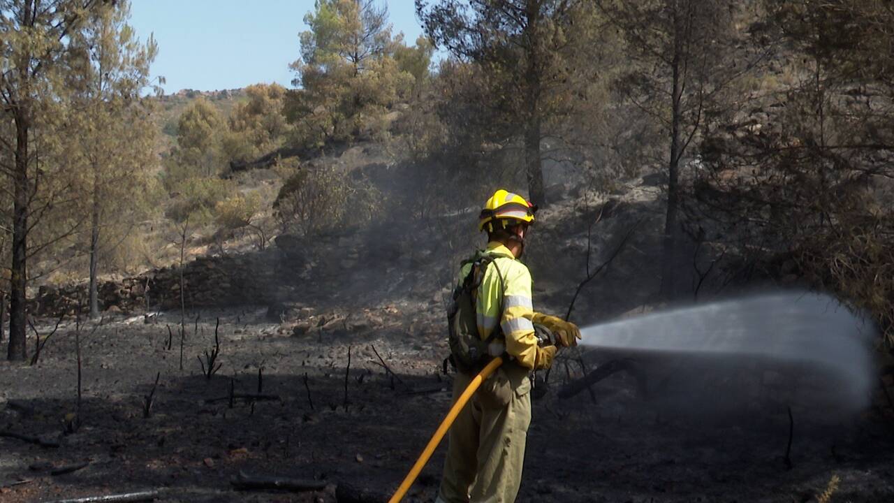 Un bombero del consorcio provincial de Castellón refresca la zona afectada en Azuébar.