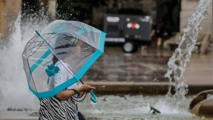 Una persona sostiene un paraguas mientras llueve, en Valencia, Comunidad Valenciana, (España)