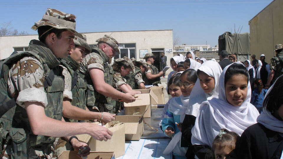 Soldados españoles repartiendo alimentos entre la población afgana