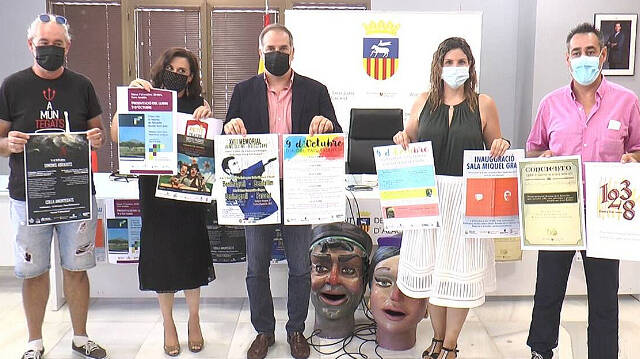 El alcalde de Sant Joan, Santiago Román, en el centro, sujetando el cartel de la discordia 