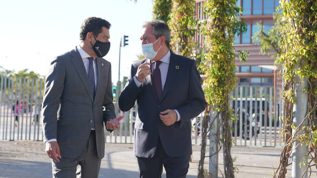 El presidente de la Junta de Andalucía, Juanma Moreno, conversa con el alcalde de Sevilla y secretario del PSOE-A, Juan Espadas, durante el acto celebrado ayer.