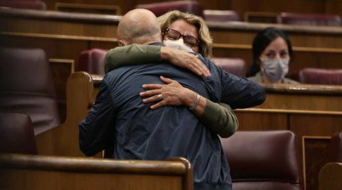 Odón Elorza se abraza a una diputada de Podemos tras su incendiaria intervención este miércoles.