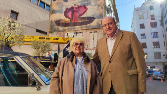 Rosita Amores y un fan posan ante el mural que se ha vuelto a instalar en Valencia