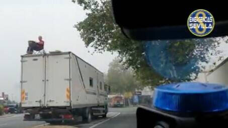 Imagen del camionero subido al vehículo esta mañana en la calle Torneo de Sevilla.