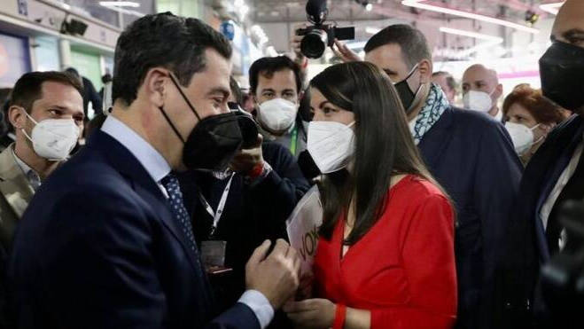El presidente de la Junta de Andalucía, Juanma Moreno (PP), saluda en Fitur a la diputada de Vox, Macarena Olona.