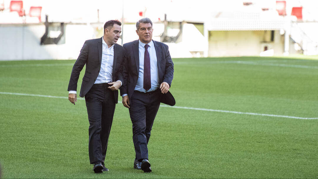 Xavi Hernández y Joan Laporta sobre el césped del Camp Nou.