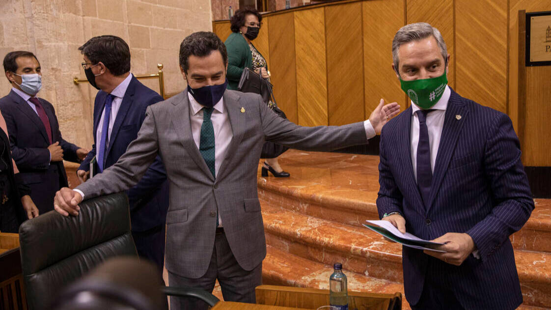 El presidente de la Junta de Andalucía, Juanma Moreno, con el consejero de Hacienda, Juan Bravo, en el Parlamento.